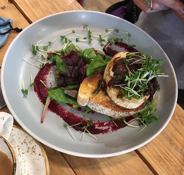 Open sandwich with greens and beetroot detail on a ceramic plate